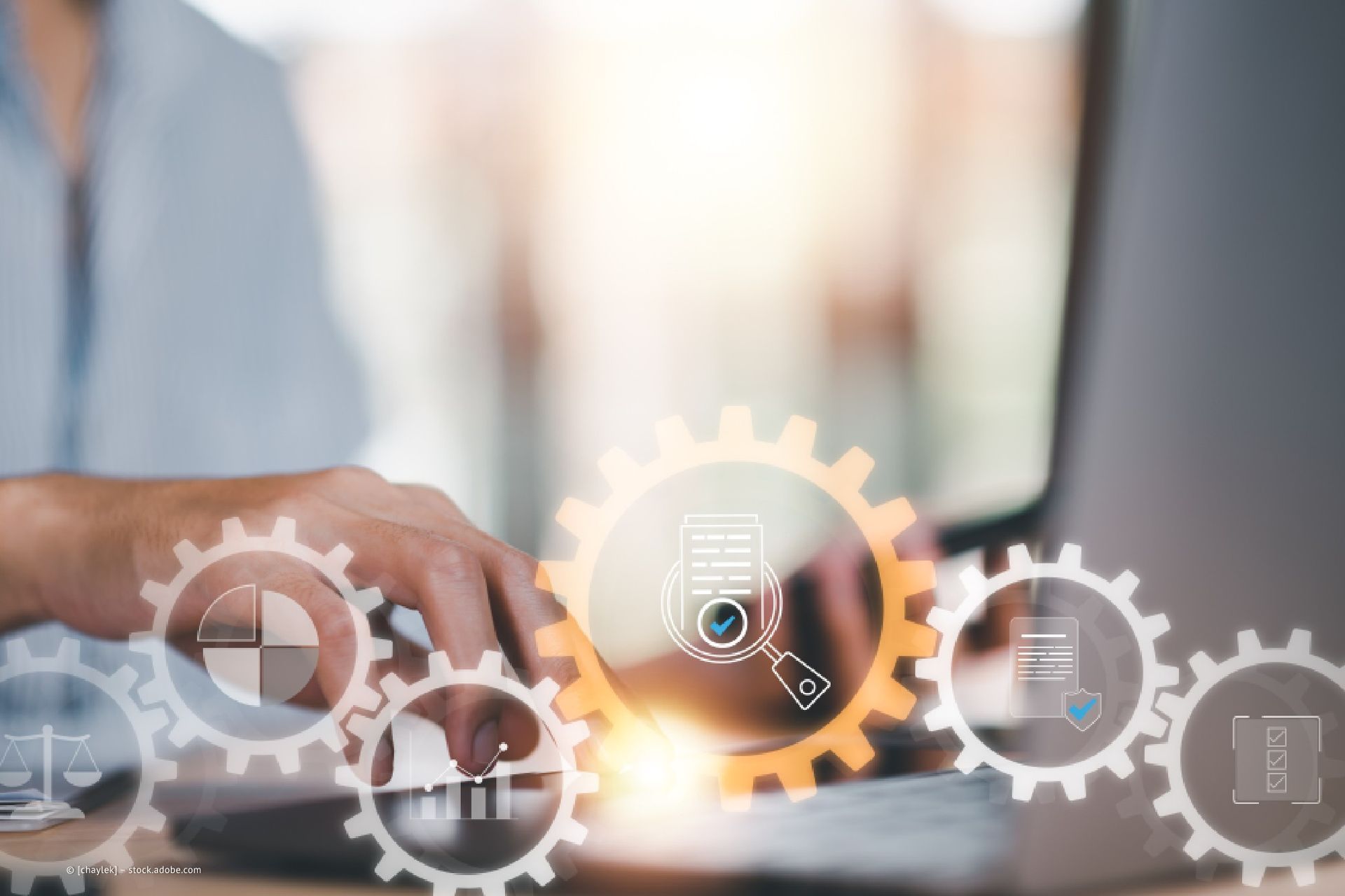 Foto von einem Mitarbeiter von Wolfgang Krupke, der am Computer arbeitet, und Zahnräder