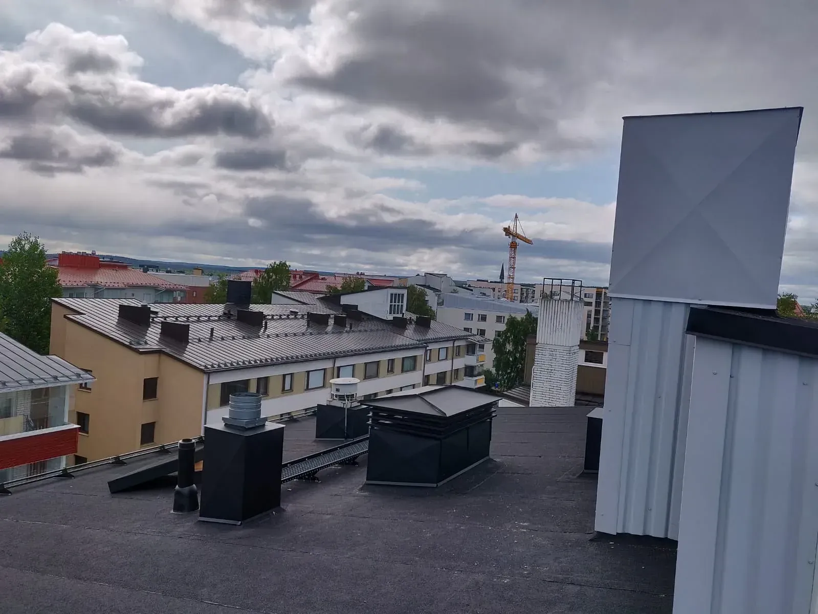 Kattonäkymä kaupungin rakennuksista pilvisen taivaan alla.