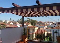 Un balcón con dosel y vista a una ciudad.