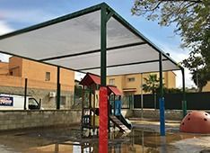 Un parque infantil con zona cubierta y tobogán.