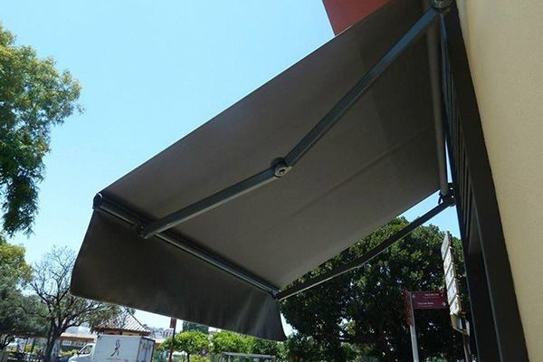 Un toldo negro está en el costado de un edificio.
