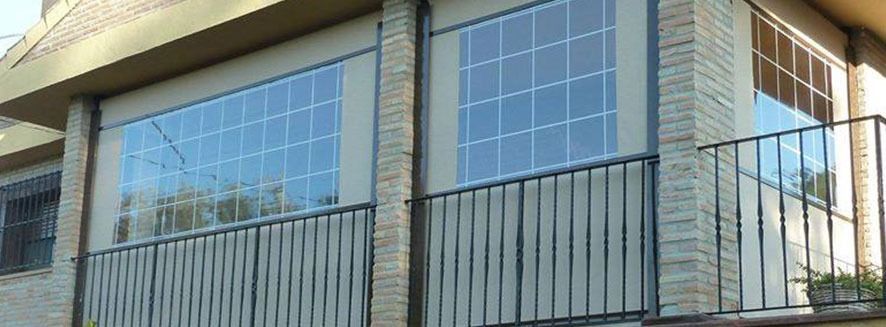 Un balcón en el lateral de un edificio con barandilla de hierro forjado.