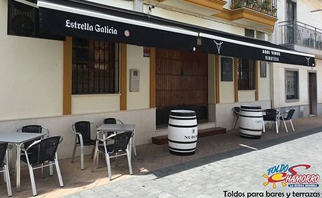Un restaurante con mesas y sillas y barriles al aire libre.