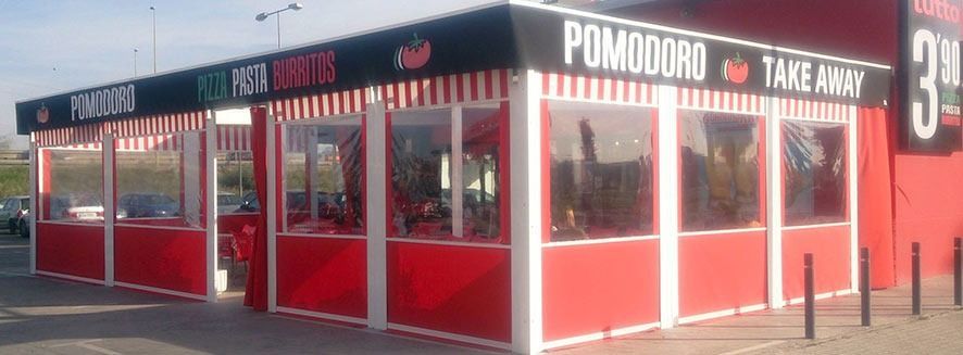 Un edificio rojo con un cartel que dice Pomodoro para llevar.
