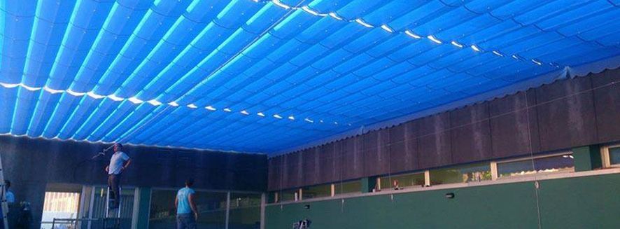 Un toldo azul cuelga del techo de un edificio.