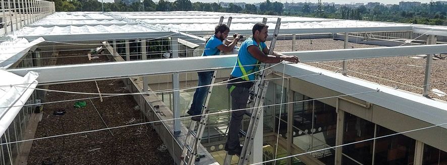 Dos hombres están trabajando en el tejado de un edificio.