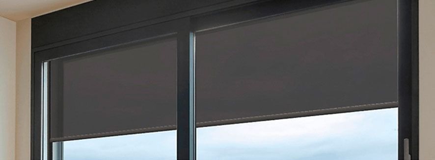 Un primer plano de una ventana con una persiana negra.