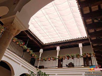 Mirando hacia el techo de un edificio con plantas en macetas colgando de él