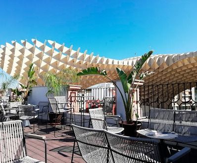 Un patio con mesas y sillas bajo un dosel.