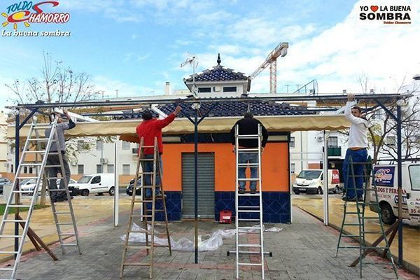 Un grupo de personas está trabajando en un edificio que dice te la buena sombra