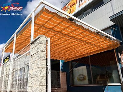 Un gran toldo naranja cuelga sobre un edificio.