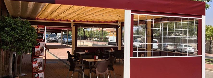 Un restaurante con mesas y sillas bajo un dosel.