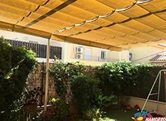 Un patio trasero con un columpio y un dosel encima.