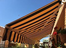 Un toldo de rayas amarillas y negras está en el costado de un edificio.