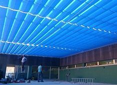 Un hombre está de pie en una escalera en una habitación con techo azul.
