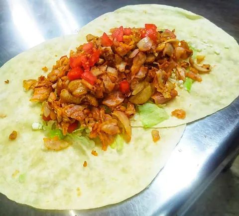 Una tortilla rellena de carne y verduras sobre una mesa.
