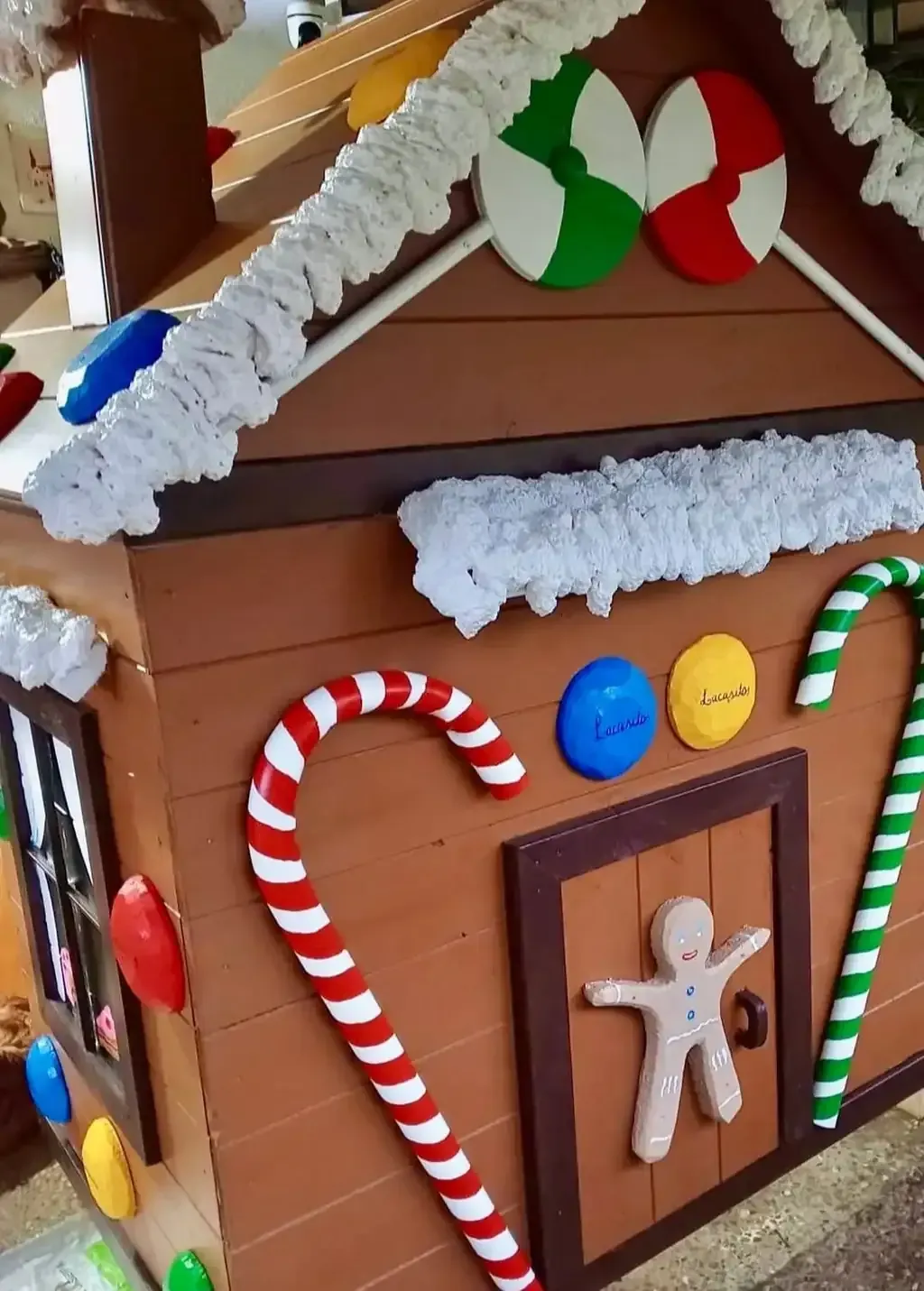 Casa de jengibre decorada con bastones de caramelo, mentas y un hombre de jengibre.