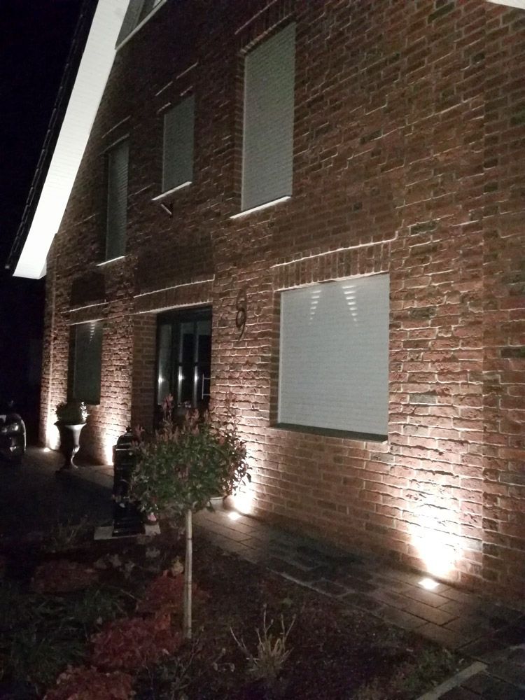 eine rote Backsteinmauer mit einem Fenster mit Rollläden