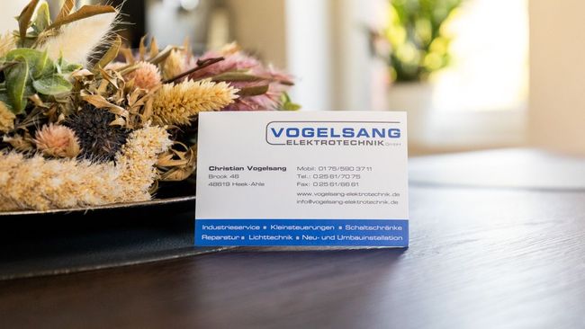 eine Visitenkarte für Vogelsang Elektrotechnik liegt auf einem Tisch