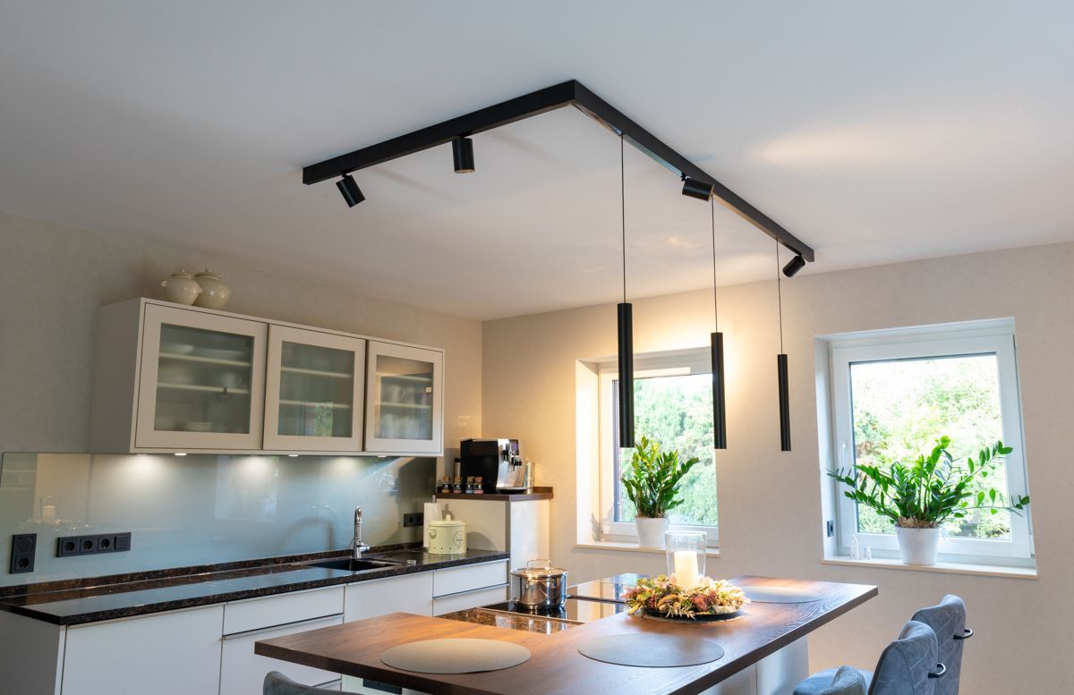 eine Küche mit weißen Schränken und einem Tisch mit einem Blumenstrauß darauf