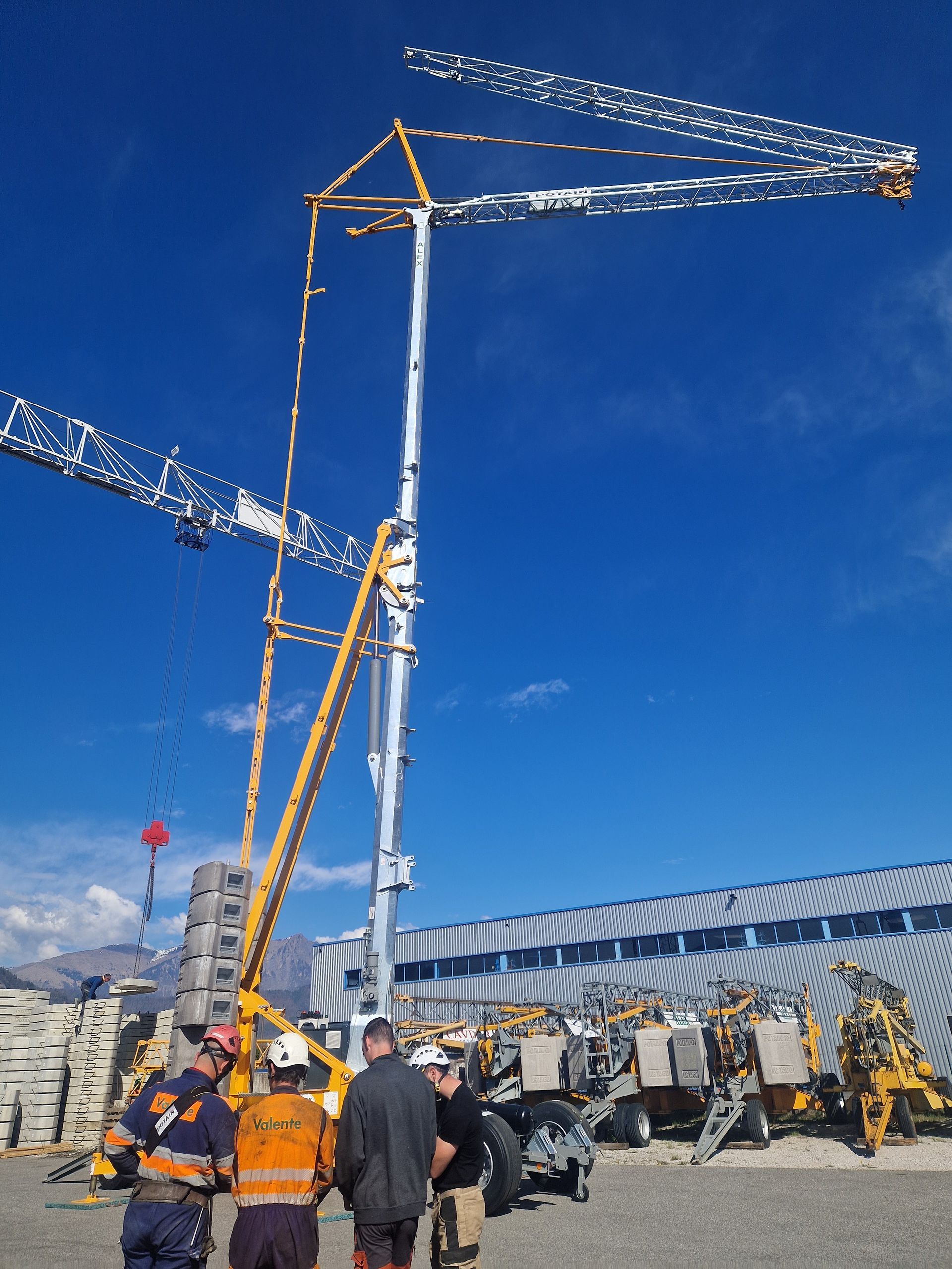 Un groupe d'ouvriers se consulte devant une grande grue.