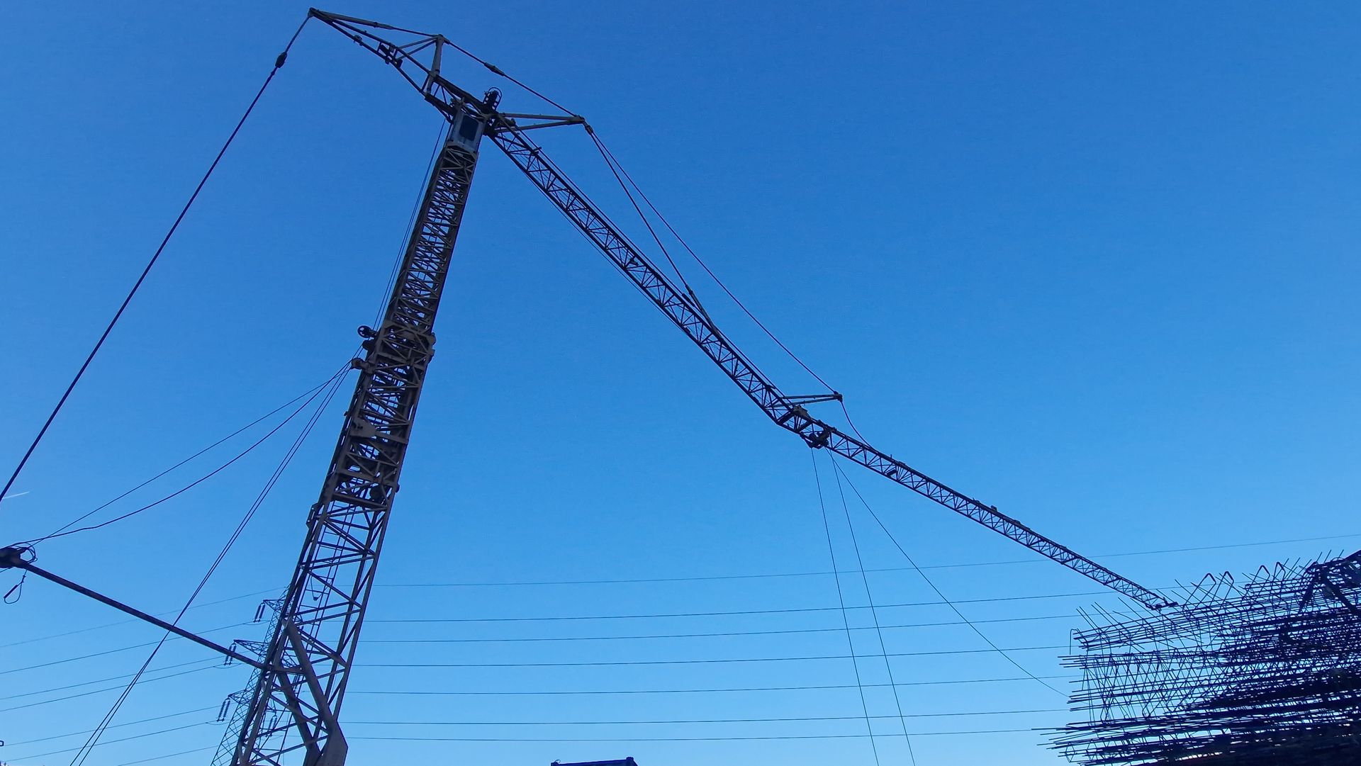 Une grande grue de chantier, ciel bleu en arrière-plan.