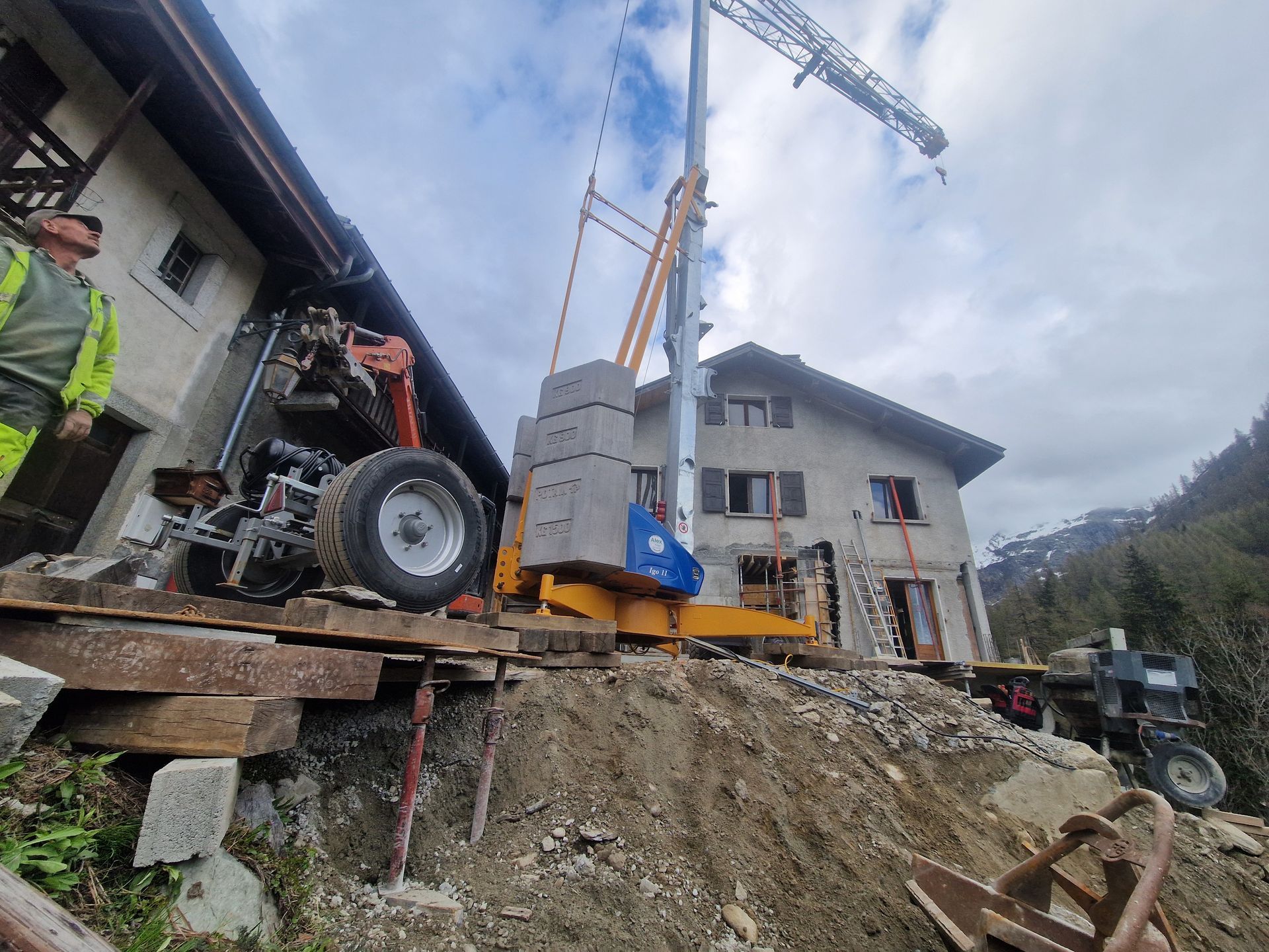 Grue soulevant des blocs de béton près d'un bâtiment, sur un chantier de construction.