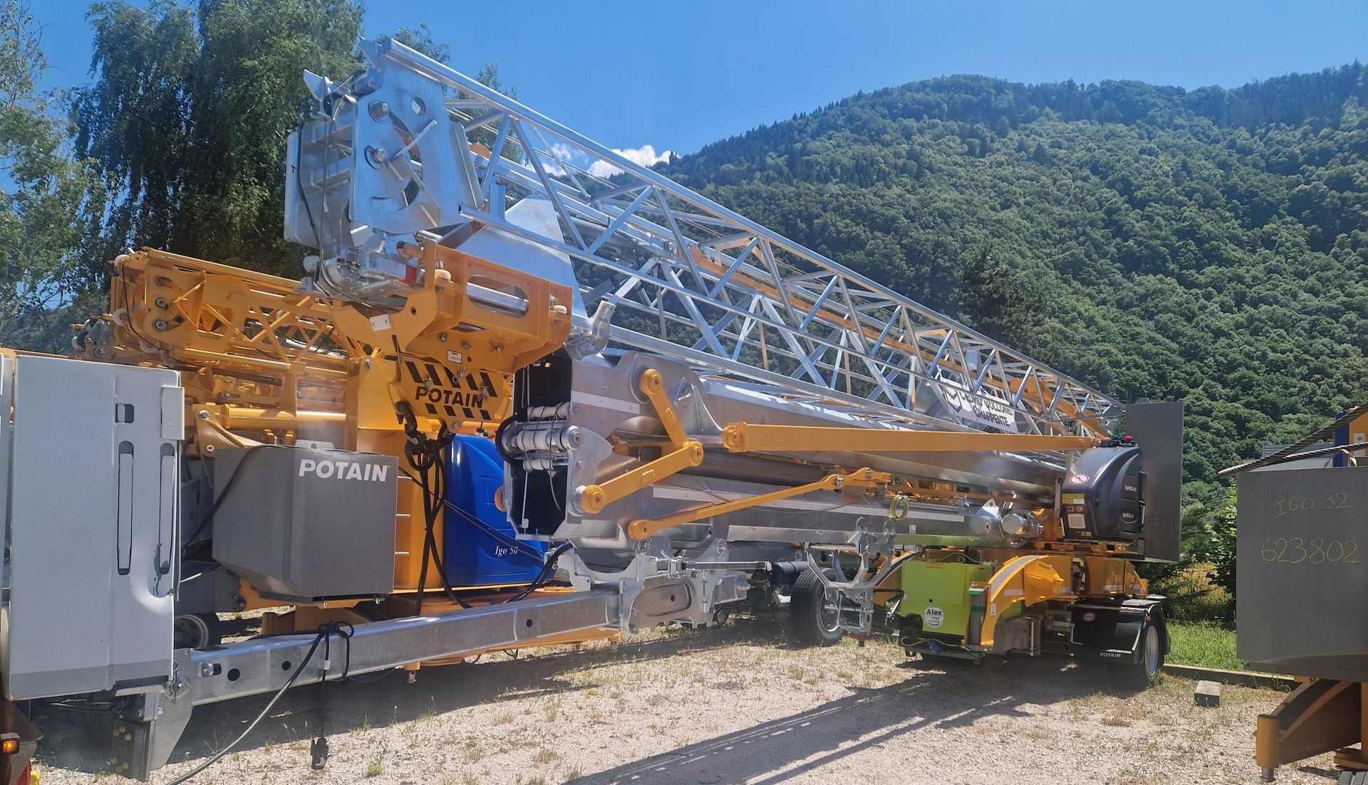 Une grande grue jaune et argentée sur une remorque, prête à être transportée.