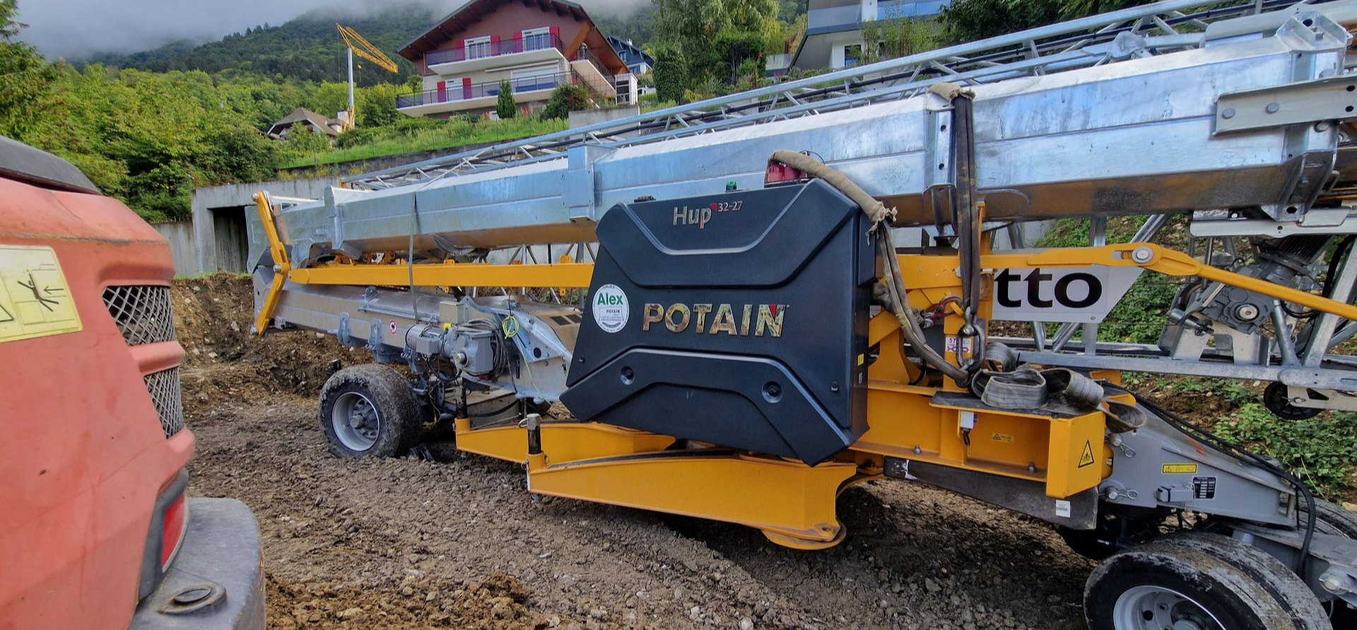 Une grande grue Potain jaune et noire en cours de transport.