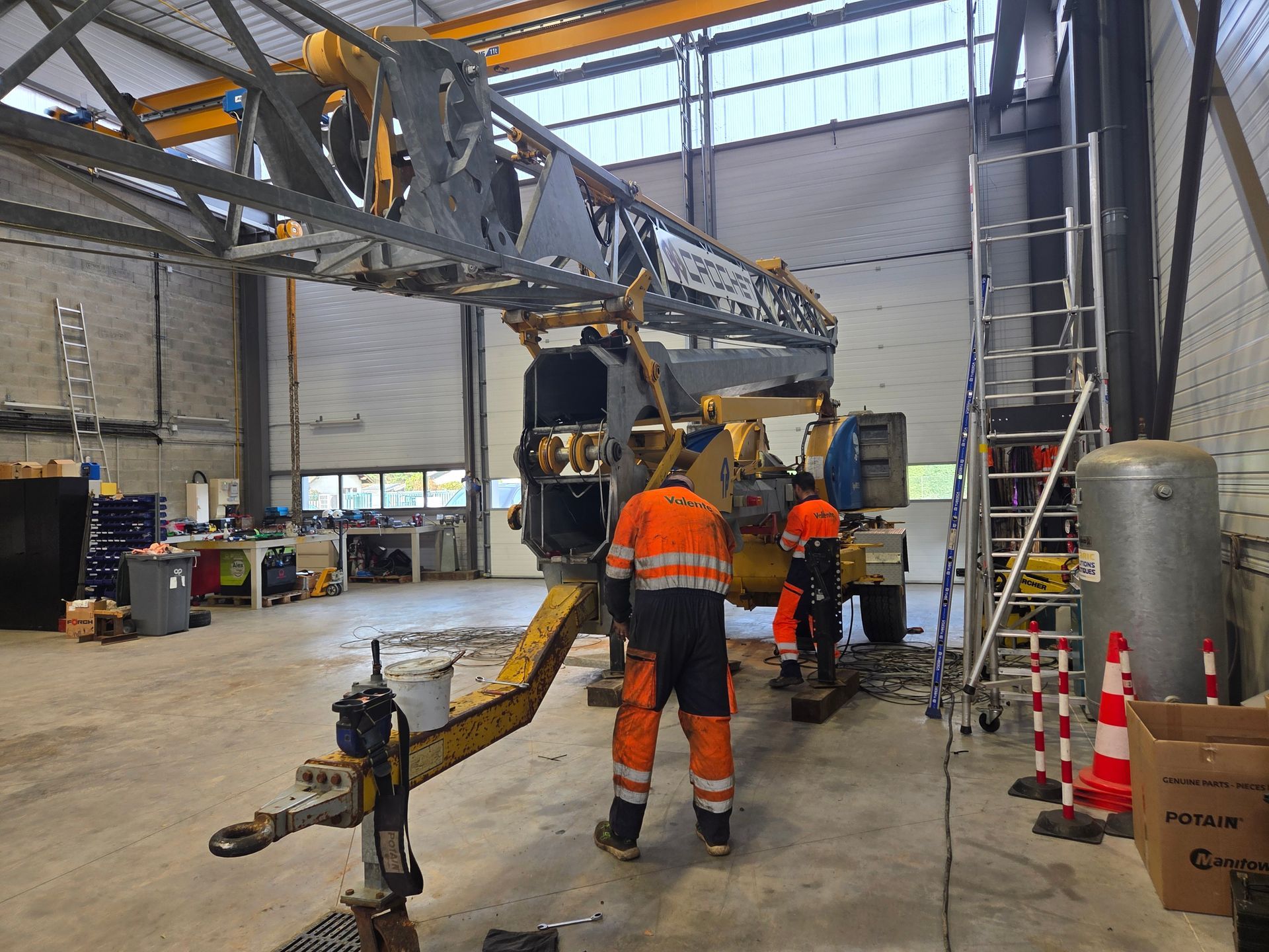 Des professionnels reconditionnent une grue de chantier d'occasion.