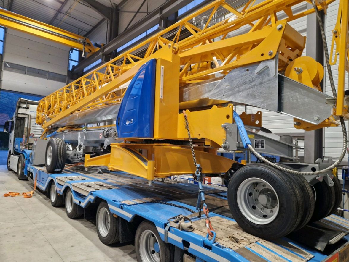 Chantier de construction avec coffrages en béton, un grand bras de pompe s'élevant vers le ciel.
