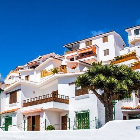 Un gran edificio blanco con un árbol delante.