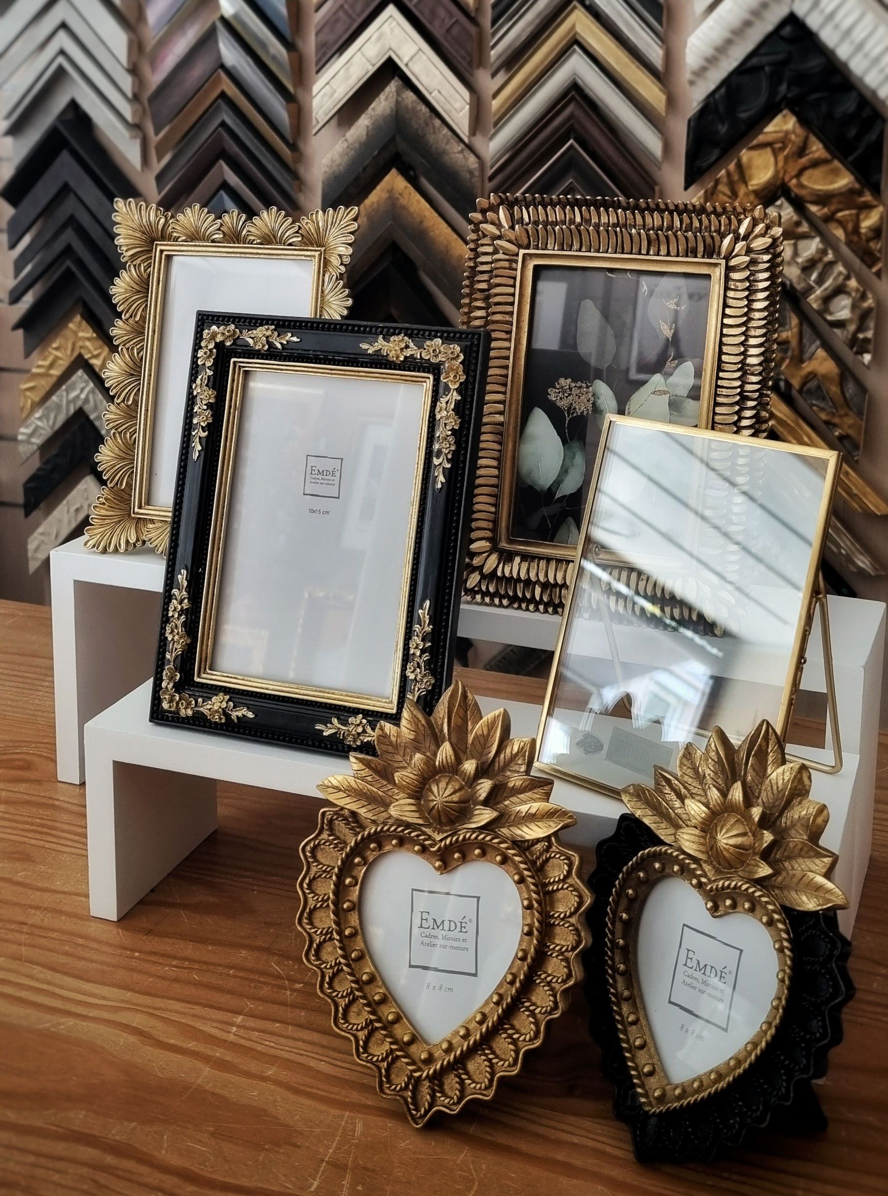 Ensemble de petits cadres dorés et noirs sur une étagère