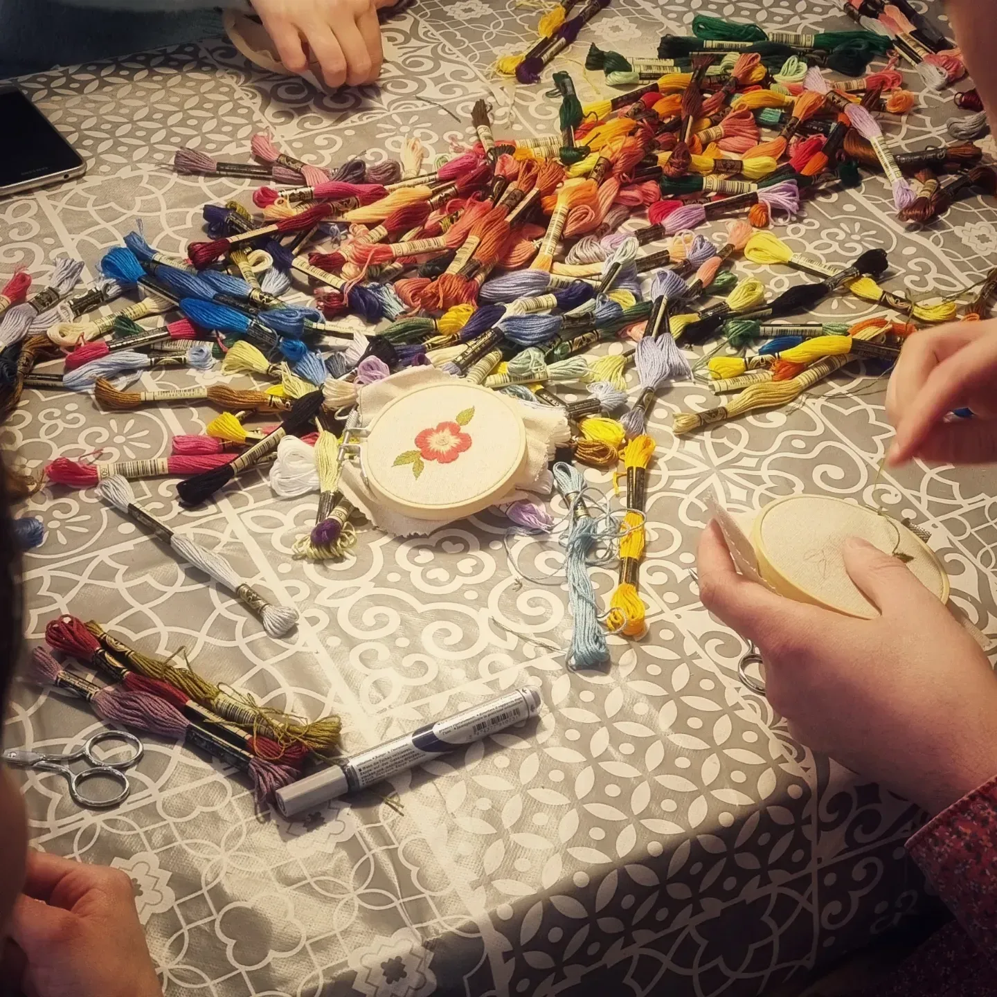 Mains en train de broder avec pleins de couleurs