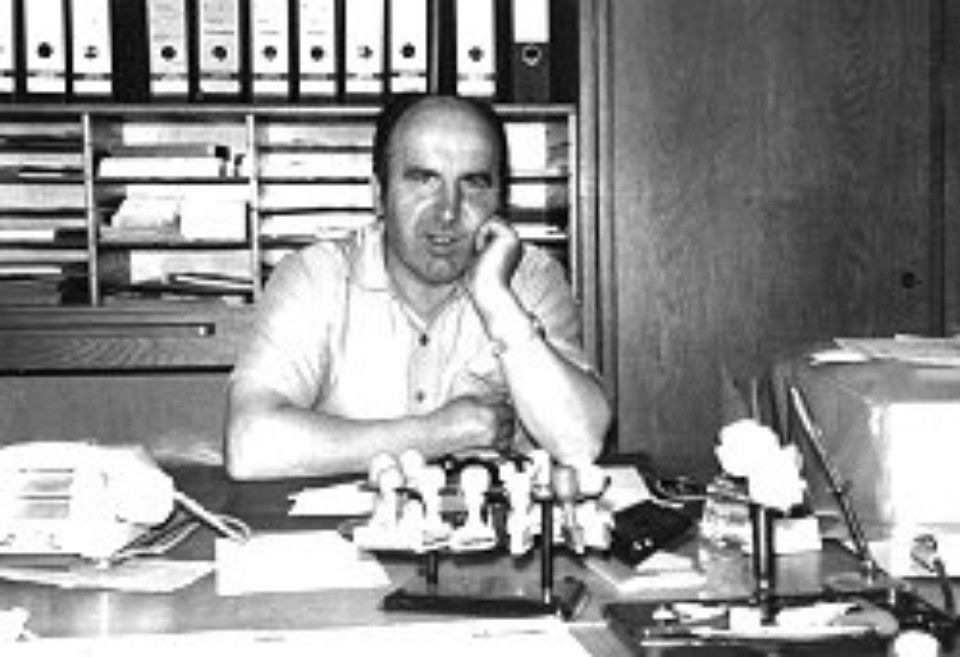 Mann sitzt vor Büroordnern und stützt den Kopf auf seine Hand