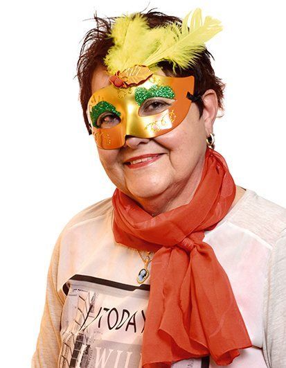 Photo de profil d'une femme avec un masque à plumes et une écharpe colorée