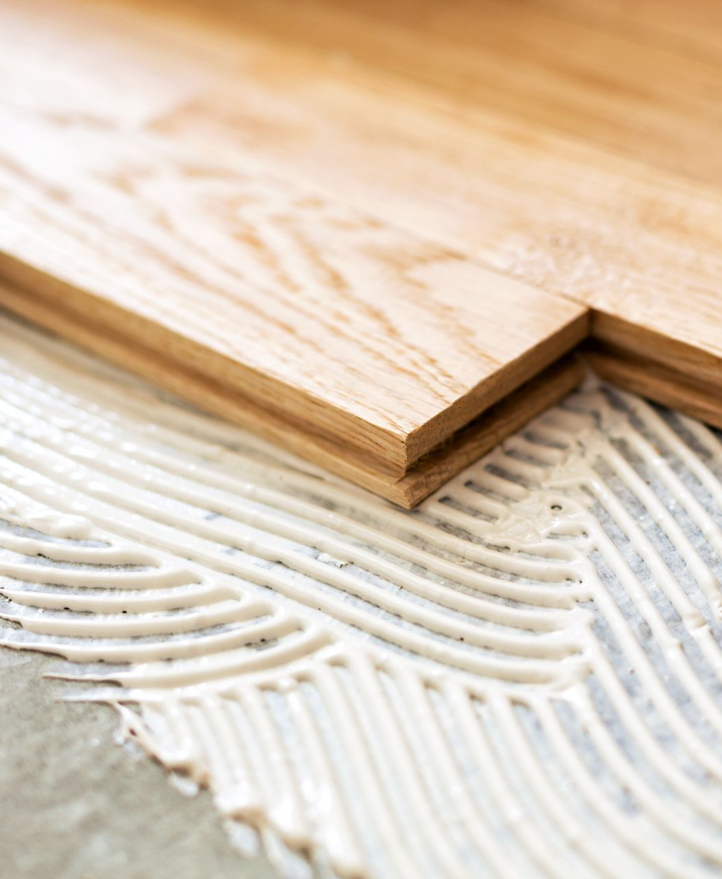 Planchers en bois installés avec de la colle sur une surface en béton.