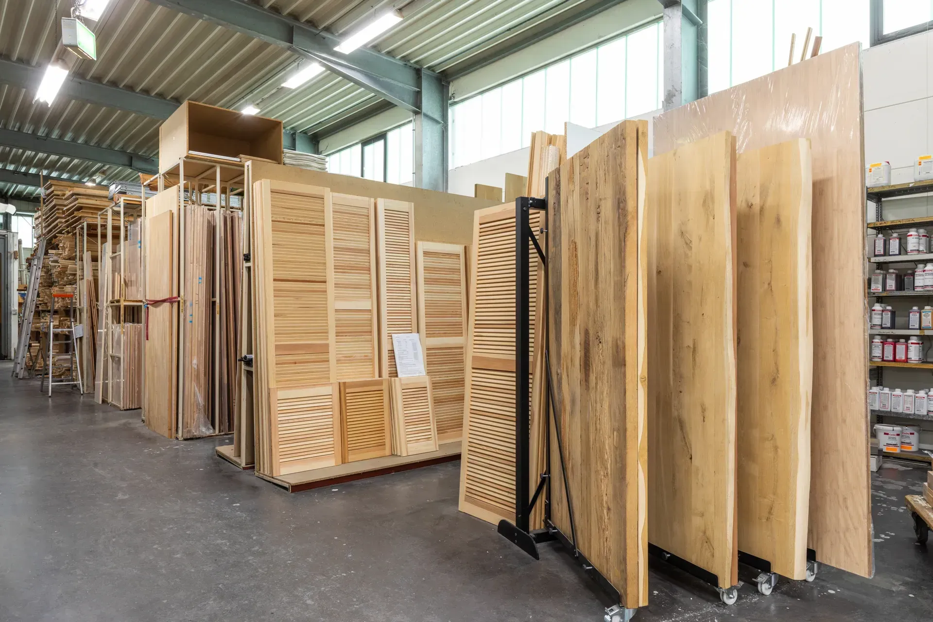 Das Interieur einer Werkstatt, in der Reihen großer Holzplatten und -planken