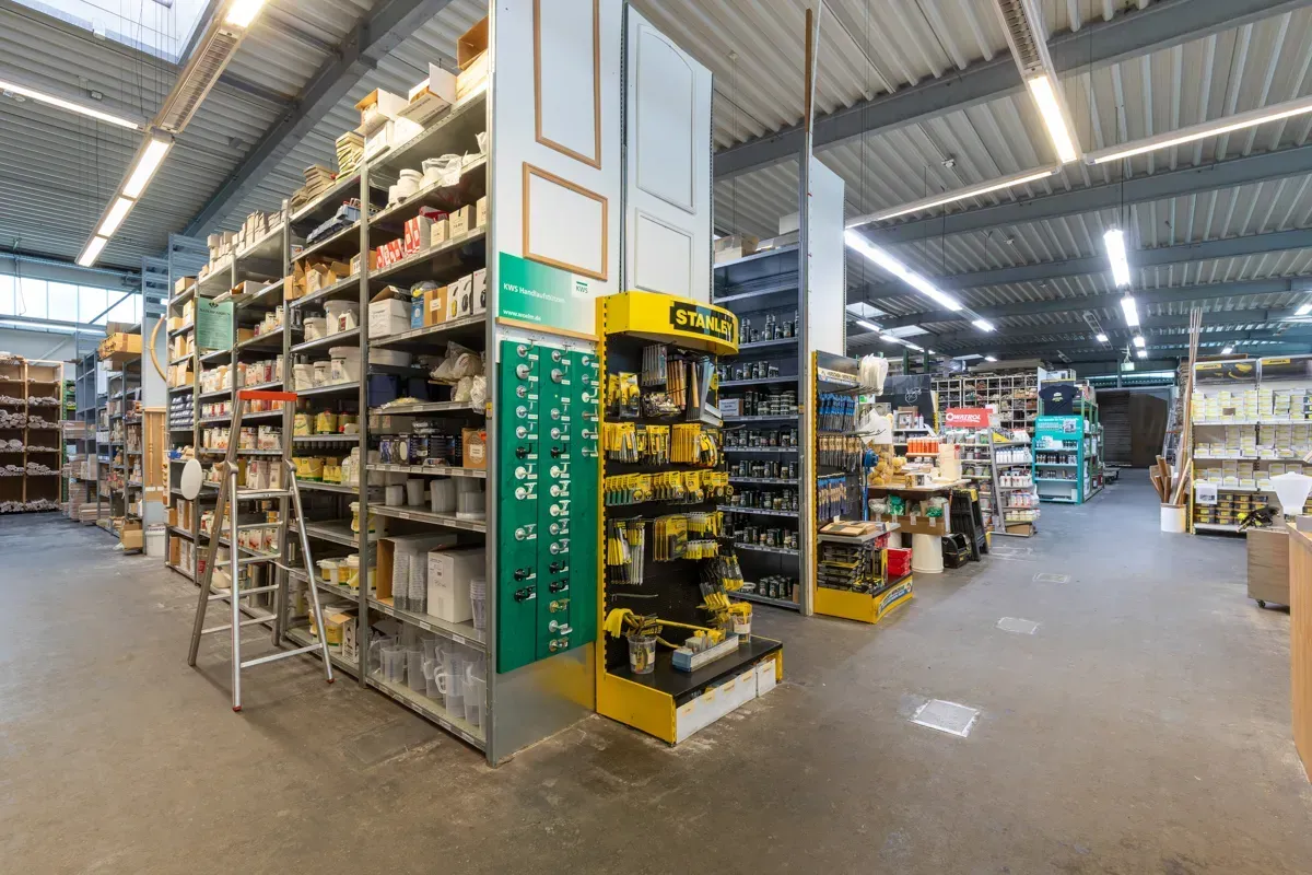 Ein Gang in einem Baumarkt mit Metallregalen voller verschiedener Artikel