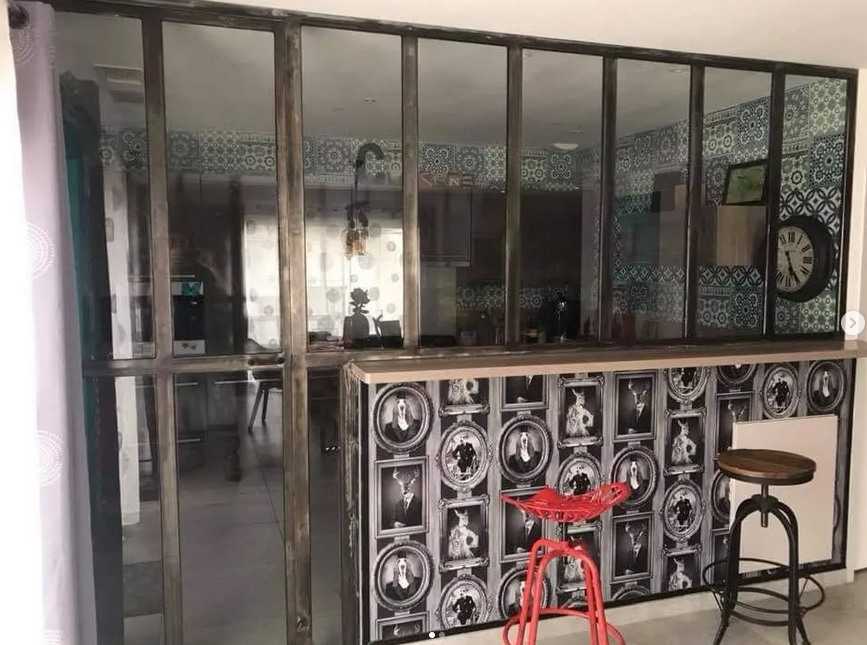 Una cocina con barra y taburetes y un reloj en la pared.