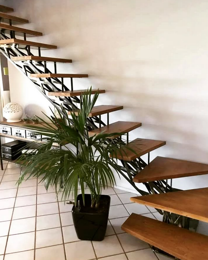 Una escalera de madera con una planta en maceta delante de ella.