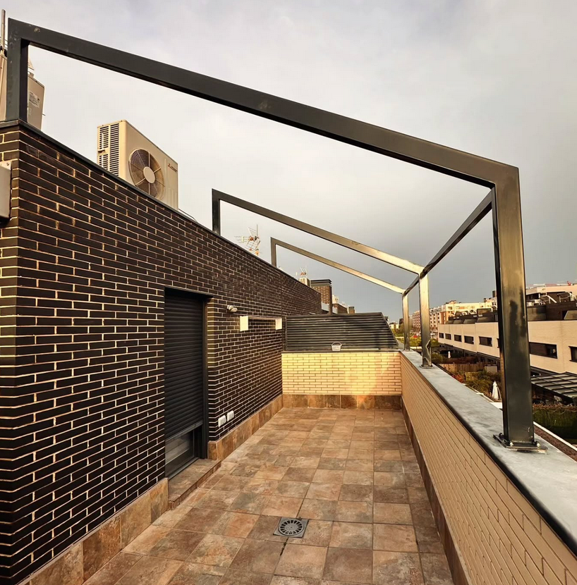 Un balcón con una pared de ladrillo y un marco de metal.