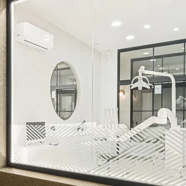 Un consultorio dental con un sillón dental y un espejo.