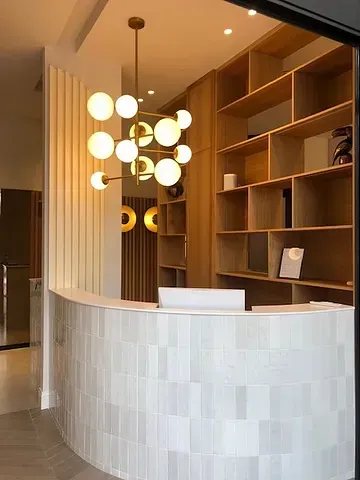 Un mostrador de recepción en una habitación con una lámpara de araña colgando del techo.