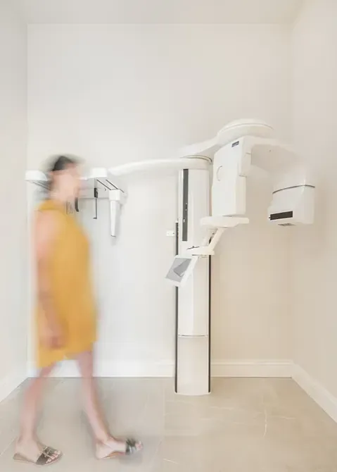 Una imagen borrosa de una mujer caminando frente a una máquina dental.