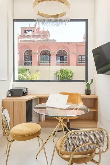 Una habitación con una mesa y sillas y una computadora portátil encima.