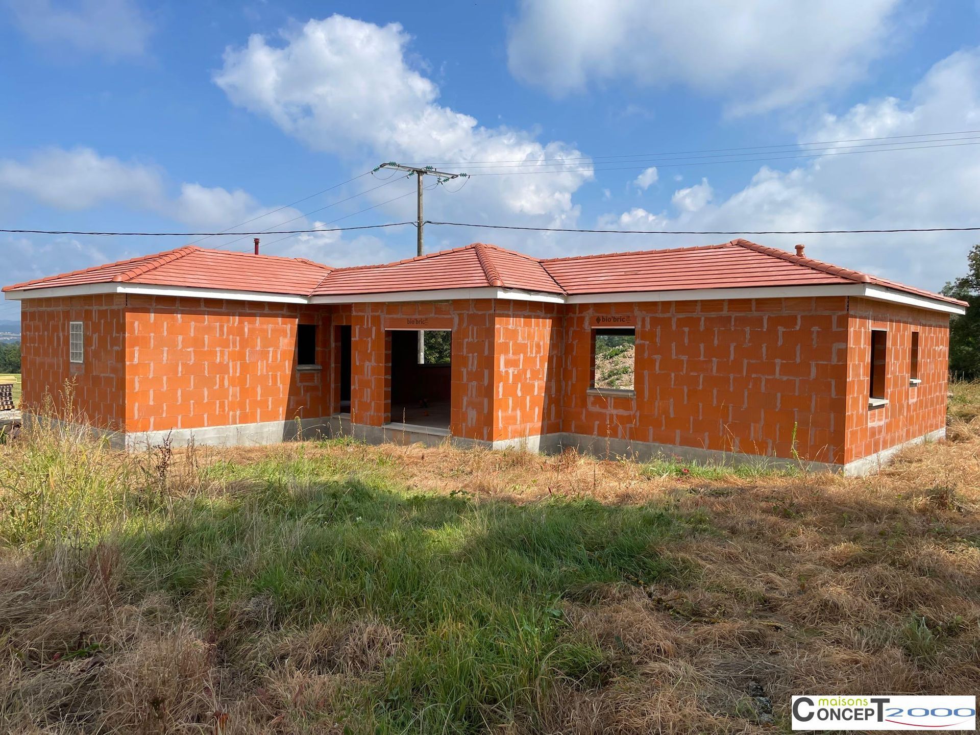 Maison en briques de plain-pied en construction, pose des tuiles