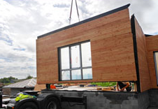 Photo de l'installation de l'une des façades d'une maison en bois