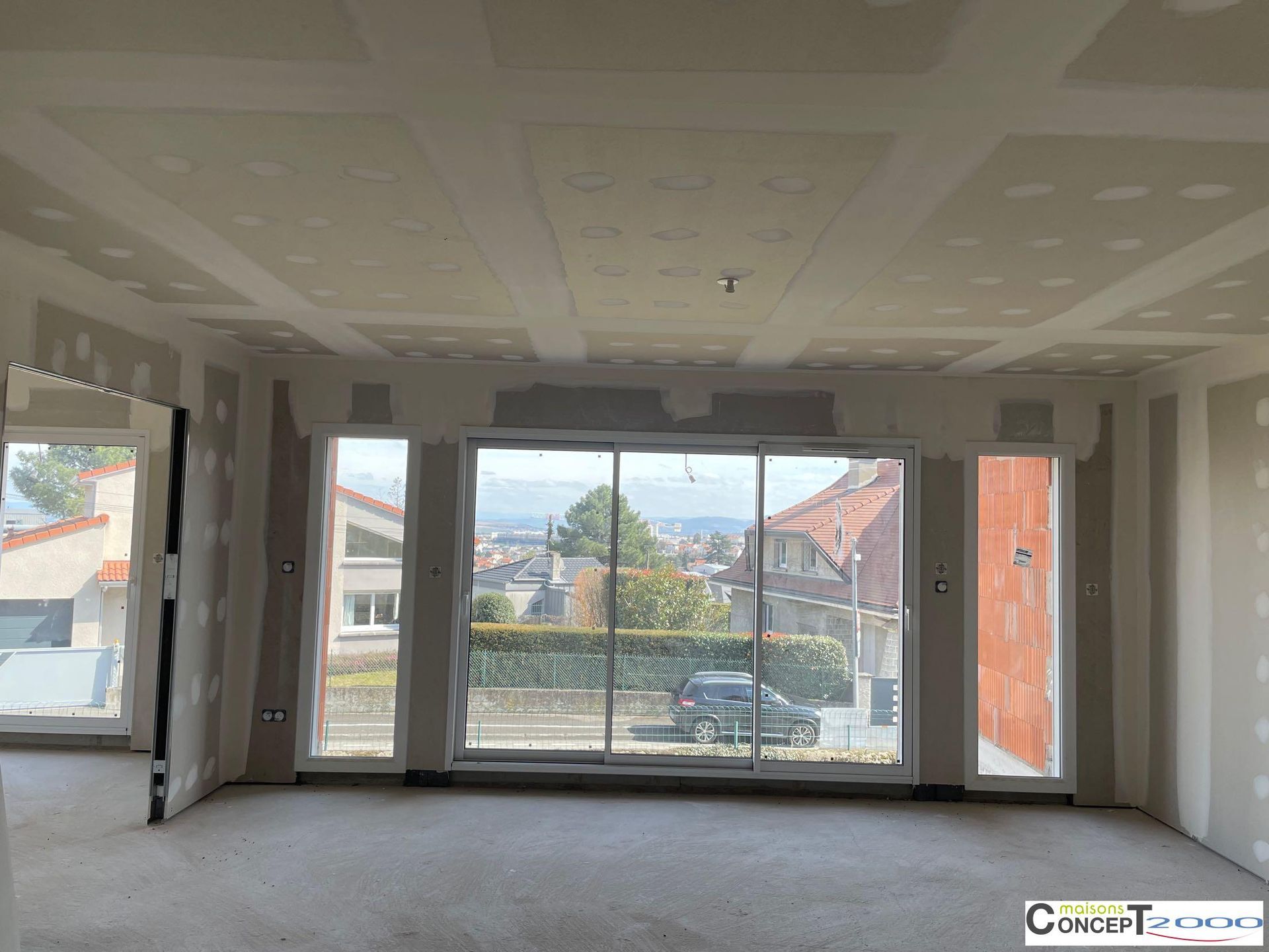 Intérieur d'une maison en construction, vue sur la baie vitrée