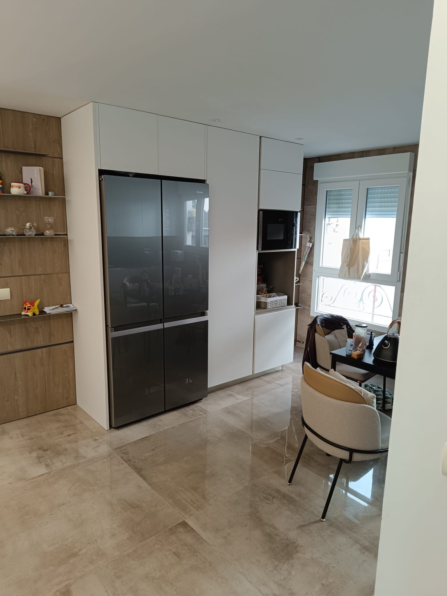 Una cocina con un refrigerador y una silla dentro.